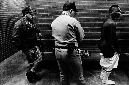 Strip Search in the “Shakedown Room” of the visiting area (1994), from Texas Death Row. © Ken Light